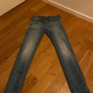 Blå jeans från Jack & Jones - Snygga blå jeans från Jack & Jones med en klassisk femficksdesign. De har en dragkedja och knapp framtill. Perfekta för en avslappnad stil. Hör av dig vid funderingar!