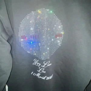 Officiell Yung Lean merch globen concert 1 mars - Snygg svart Yung Lean merch med röd text på framsidan och ett glittrigt mönster på baksidan. Den har en justerbar huva med dragsko och en stor ficka framtill. Köptes på globen concerten och har inte använt mycket