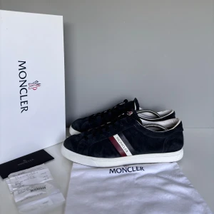 Moncler skor - Säljer ett par sjukt snygga Moncler skor i storlek 43, cond 7,5/10 heeldrag och sliten mocka längst fram, annars bra skick på resten av skon! Skorna är behandlade med vit skokräm och impregneringsspray. Kommer med all OG inklusive KVITTO!