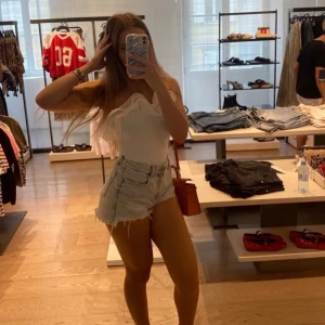 Vit axelbandslös topp med volang - Säljer en stilren vit axelbandslös topp med vackra volangdetaljer. Perfekt för sommarens varma dagar. Toppen har en tight passform och är tillverkad i ett mjukt material. S men passar även M. Helt oanvänd. Kostade 399. Säljer då jag behöver pengar för min hund på veterinär, så tar betalt via Swish för snabb inkomst ❤️