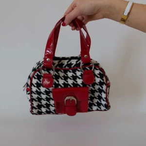 Rutig handväska med röda detaljer - Snygg handväska med svartvitt rutigt mönster och röda detaljer. 