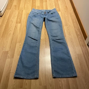 Lågmidjade bootcut jeans  - (32) Ljusblåa lågmidjade bootcut jeans med stretchigt material, midjemått rakt över: 37 cm, innerbenslängd: 82 cm 💖