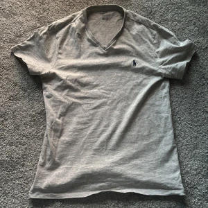 Grå t-shirt från Polo Ralph Lauren - Säljer en stilren grå t-shirt från Polo Ralph Lauren med en liten broderad logga på bröstet. Hör av er vid minsta fråga eller fundering. Pris kan diskuteras