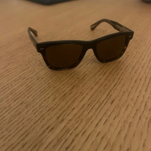 Bruna solglasögon från Oliver Peoples - Snygga bruna polariserade solglasögon från Oliver Peoples en av de mest populära modellerna Oliver Sun. Knappt använda och alla tillbehör finns kvar. 