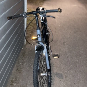 Säljer en grå svart cykel - Lite trasig sadeln men  är i acceptabelt skick   iallafall och lite slöa trampare Det är en barn cykel 