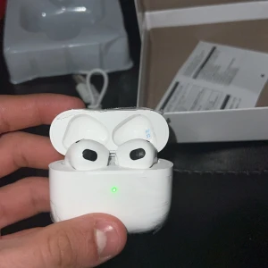 Trådlösa hörlurar med MagSafe-laddningsetui - Säljer ett par trådlösa hörlurar med MagSafe-laddningsetui. Hörlurarna är vita och kommer i originalförpackning med laddningskabel och manual. Perfekt för musik och samtal med hög ljudkvalitet.