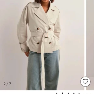 Beige trenchcoat med bälte - Snygg beige trenchcoat med knappar och bälte i midjan. Jackan har långa ärmar och en klassisk krage. . Storlek xs men passar S (den är 3 dagar ny och aldrig använd) skriv för egna bilder 💕