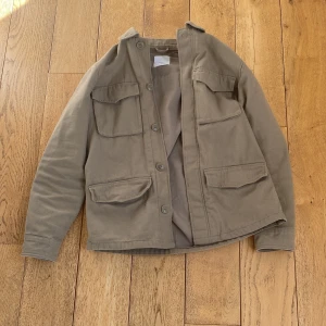 Overshirt med knappar - Säljer en stilren overshirt med knappar framtill och fyra praktiska fickor. Perfekt för lager-på-lager stilen. Säljer då den inte passade mig. Skick 9,5/10, inga defekter eller skador. Tveka inte på att höra av er vid mått och liknande. 