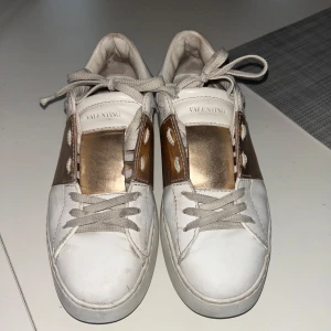 Valentino sneakers i vitt och guld - Snygga Valentino sneakers i vitt skinn med gulddetaljer o perfeka nu inför våren! säljer då de är något för små🩷kan tänka mig byta mot ett par valentinos med svarta detaljer i strl 38,5 elle 39🩷eftersom de är i italienska storlekar står det att storleken är 36 1/2 men de är lite för små för mig som har strl 38-39!