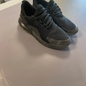 Svarta sneakers från Nike - Pris kan diskuteras vid snabb affär Snygga svarta sneakers från Nike med en luftig mesh-ovandel och robust sula. Skorna har en modern design med snörning och en synlig luftkudde i hälen för extra komfort. Perfekta för både träning och vardag.