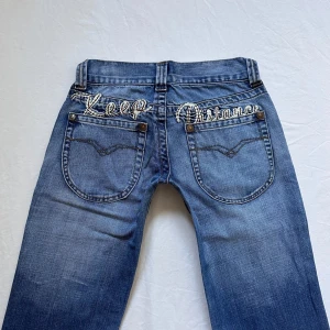 Lågmidjade bootcut jeans - Vintage från Clockhouse med tryck bak💓midja 34 innerben 83