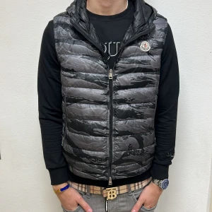 Moncler väst med luva - Helt sjuk unik väst med luva, Storlek 2, givetvis autentisk. Endast 2399. Ställ frågor vid intresse. 8/10 skick, dragkedjan lite krasslig men märks ej.