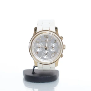 Michael Kors vit och guld klocka - Stilren klocka från Michael Kors, modell MK-5145, med vit länkarmband och guldfärgad boett. Urtavlan är silverfärgad med guldiga detaljer, tre små urtavlor och datumvisning. Tillverkad i rostfritt stål och har en modern, chunky design.                                                          Behöver ett nytt batteri.