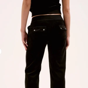 Svarta velourbyxor Juicy Couture XXS - Svarta mjukisbyxor från Juicy Couture i velour med snörning i midjan och fickor med knappdetaljer bak. Snyggt avslappnad passform och klassisk look. Ordinarie pris ca 1200💞