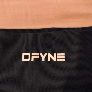 MÖRKBLÅ ribbade träningsshorts DFYNE - Snygga mörkblå träningsshorts från DFYNE med ribbad struktur och hög midja. Stretchigt material som sitter tight och formar kroppen. Logga framtill i vitt. Perfekta för gymmet eller sport. Kort modell med seamless design för extra komfort.