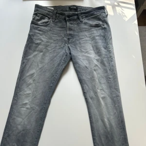 Grå Jack&Jones jeans - Säljer ett par snygga och sköna Jack&Jones jeans i modellen slim/glenn. De är i storlek 33/30 och jag säljer dessa för 75 kr. Hör av vid frågor🙌