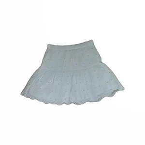 Vit kortkjol med volang - Supersöt vit kortkjol med volangkant och broderade små prickar. Köpt på Lindex i början av sommaren, använd fåtal gånger och i mycket fint skick! Superfint till utekvällar och middagar men även för att bara ha på dagen, passar i princip till allt!🌸