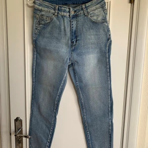 Ljusblå skinny jeans - Säljer ett par ljusblå skinny jeans med klassisk femficksdesign och dragkedjegylf. Jeansen har en smal passform och är tillverkade i mjukt denimtyg som ger en bekväm känsla. Perfekta till sneakers och hoodie för en avslappnad look.