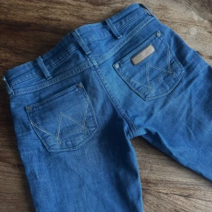 Low waist bootcut wrangler jeans - Från wrangler, modell megan, stl 26/32 Sanna till storlek. Inga defekter såsom hål eller fläckar. Säljes pga för små.