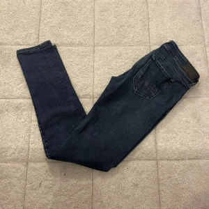 Replay mörkblå skinny jeans - Snygga mörkblå jeans från Replay med skinny passform och klassisk femficksdesign. Jeansen har en smal siluett, normal midja och är tillverkade i stretchigt denim som sitter bekvämt. Perfekta för dig som gillar en stilren och modern look.små i storlekarna
