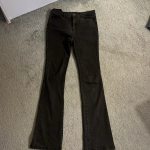 Svarta bootcut jeans Designers Remix - Snygga svarta jeans från Designers Remix med bootcut passform. Jeansen har klassiska fyra fickor, bälteshällor och stängs med knapp och dragkedja. Materialet är jeans och färgen är en mörk svart ton. 