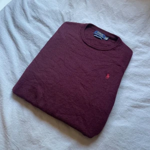 Ralph Lauren merinoull tröja S – vinröd, rundhalsad -  Polo Ralph Lauren tröja – Merino Wool ✨ Storlek: Märkt XL men passar som S (se mått!) Material: 100% Merino Ull. Färg: Vinröd / Burgundy Modell: Rundhalsad  Exklusiv och tidlös Ralph Lauren merinoulltröja i vacker vinröd färg. Rund halsringning gör den enkel att matcha – perfekt både till vardags och en mer dressad look.  ✔️ 100% fin merinoull – mjuk, varm & lyxig känsla ✔️ Märkt XL men krympt, motsvarar storlek S ✔️ Stilren design i klassisk färg.           🚀 Skickas snabbt & välpackat!   