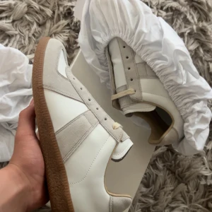 Maison margiela skor - Elegenta Maison margiela Gats i en Vacker off white nyans⚜️ Skick: 10/10🧮 Inkluderat: Box, 2 Dustbags, Skor, kort♦️ Pris: 3899🎗️ Storlek: 43♣️ Snabbaffär = priset sänks-SERIÖSA BUD🔓