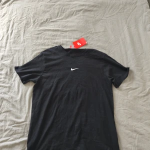 Svart Nike t-shirt - Klassisk svart t-shirt från Nike med vit logga på bröstet. Enkel och stilren modell som passar både till vardag och träning.