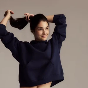 Mörkblå croppad hoodie - Snygg mörkblå croppad hoodie med huva och magficka. Tröjan har en loose passform och långa ärmar, perfekt för en chill och avslappnad stil. Passar grymt till både jeans och mjukisbyxor.