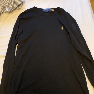 Svart långärmad tröja Polo Ralph Lauren - Svart långärmad tröja från Polo Ralph Lauren i bomull med broderad logga på bröstet. Modellen är slim fit och har en klassisk rund halsringning. Perfekt för dig som gillar stilrena och tidlösa plagg med en sportig touch. Knappast använd 3-4 gånger typ. 🤩
