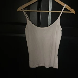 Vit linnetopp från Gina Tricot XS - Enkel och stilren vit linnetopp från Gina Tricot, modell Basically Basics. Tunt material med smala axelband och rak passform. Perfekt att matcha med jeans eller kjol för en clean look.