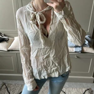 En fin blus (den behövs strykas) -  En fin beige blus med en rosett som är från ILSE JACKOBSEN vilket är ett väldigt fint märke, som ni ser behövs blusen streckas  (4 blus Ilse Jacobsen cream 4)