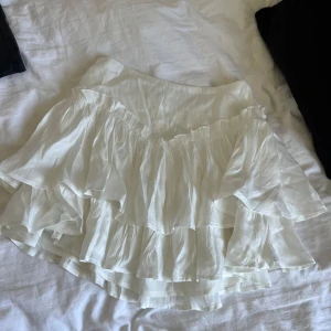 Vit volangkjol  - Supersöt vit kortkjol med flera lager volanger.