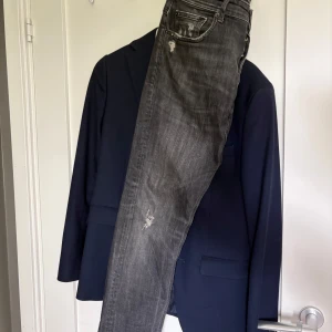 Replay grå/svart slitna jeans - Säljer ett par schyssta jeans från Replay med slitningar och distressed detaljer. Passar perfekt nu till sommaren med ett par med avslappnade schysstare jeans som dessa, slim modell. Hör av dig vid frågor, allt gott!