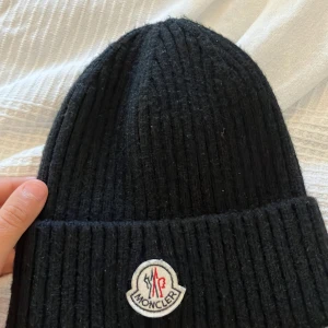 Moncler mössa  - Säljer min moncler mössa den är perfekt till till kyliga dagar det står mitt namn i I den men hoppas det inte är nåt problem