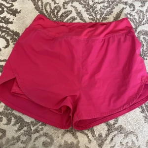 Rosa träningsshorts från Shein - Snygga rosa träningsshorts från Shein med elastisk midja och innershorts. Perfekta för sport eller chill dagar. Lätta och bekväma med en sportig look.