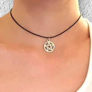 Snygg choker pentagram pentacle silver imitation  - Ett pentagram trädd på en kortare svart tråd som är justerbar 35-40 cm. Berlocken är ca 1,6 cm i diameter.  