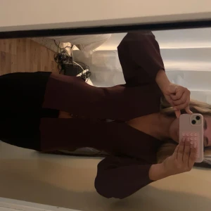 Vinröd figursydd kofta  - Säljer en vinröd kofta med v-ringad hals och snygga knappar framtill. Koftan har långärmade ärmar och en figurnära passform som markerar midjan. Perfekt för dig som vill ha en stilren och trendig look❣️