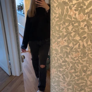 Svarta jeans med slitningar - Snygga svarta jeans med egengjorda slitningar på knäna. De har en klassisk femficksdesign och knappgylf. Skulle säga att de passar storlek 36/38 💗