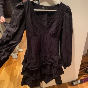 Volangklänning från Zara - Världens snyggaste klänning från Zara med volanger och v-ringning. Går inte att få tag på längre.  Klänningen har långa ärmar och en kort längd. Tyvärr blivit för liten🥲 använd ca 2 ggr🩷(lånad bild)