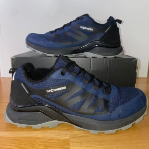Mörkblå Vattentäta Vandringsskor från Stormberg - Snygga och funktionlla vattentäta blå vandringsskor från Stormberg med svarta detaljer och snörning. Normal passform. Perfekt för utomhusaktiviteter i alla väder. Sulan är 25,5 cm från början till slut