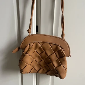 Brun axelväska med flätad design - Snygg brun axelväska mee flätad design.