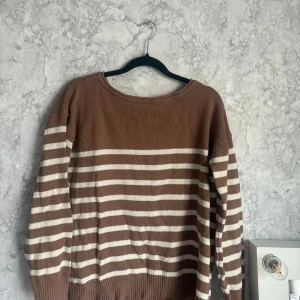 Brun och vit randig tröja från VILA - Säljer en snygg brun och vit randig tröja från VILA. Tröjan har långa ärmar och är perfekt för en avslappnad stil. Den är gjord i ett mjukt material som känns skönt mot huden. Perfekt för höst och vår!