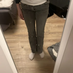Grå jeansbyxor från Gina Tricot - Snygga grå jeansbyxor från Gina Tricot med en klassisk femficksdesign. Byxorna har en rak passform och är perfekta för en avslappnad stil. De har en knapp och dragkedja framtill.