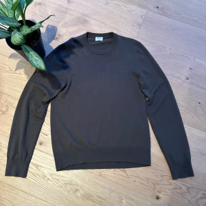 Brun tröja från Filippa K - Snygg brun/mörgrön tröja från Filippa K i bomull. Perfekt för en stilren look med rund hals och långa ärmar. Passar bra till både jeans och chinos.