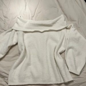 Vit offshoulder tröja - Säljer en stilren vit offshoulder tröja med långa ärmar. Perfekt för en elegant och avslappnad look. Tröjan har en bred krage som ger en unik touch. Passar bra till både jeans och kjol.