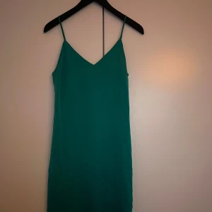 Grön axelbandslös klänning - Snygg grön klänning med smala axelband. Från vila. 