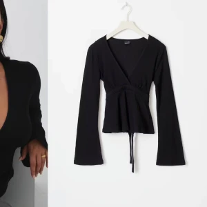 Svart v-ringad topp från Gina tricot  - Snygg svart v-ringad topp från Gina tricot med långa ärmar och knytband i midjan. 