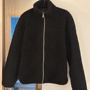 Svart teddyjacka från New Look - Mysig svart teddyjacka från New Look med dragkedja framtill. Jackan har en klassisk design med långärmade ärmar och en mjuk, fluffig yta som håller dig varm under kyliga dagar.  Nypris 620kr. Skriv för frågor!💞💞