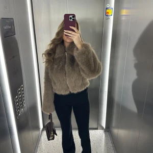 Brun pälsjacka från ASOS DESIGN - Säljer en snygg brun fuskpälsjacka från ASOS DESIGN. Jackan har en dragkedja framtill och är långärmad med en fluffig look. Endast använd fåtal gånger! Perfekt för att hålla sig varm och stilren under kyliga dagar. 🧥✨